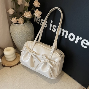 Détail d'un sac cabas crème avec deux poches à nœuds coulissants et fines bandoulières