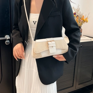 White croc-effect leather crossbody bag with metal buckle shown on model in urban style