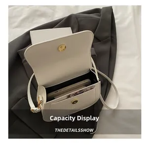Detail view of cream leather crossbody bag interior showing phone slot and card holders