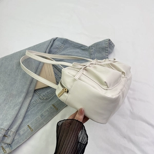 Vue détaillée d'un sac cabas blanc avec décoration de nœud et détails dorés du zip