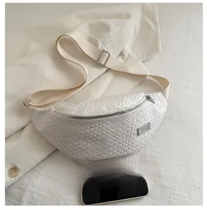 Detail of white woven chest bag texture with adjustable canvas strap and silver buckle