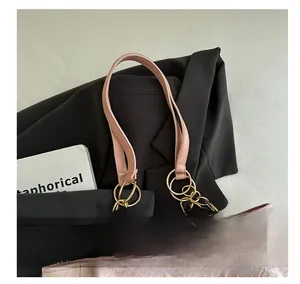 Detail of pink canvas tote featuring floral embroidery and gold metal chain handles