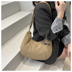 Détail du sac croissant kaki avec texture plissée et bandoulière réglable pratique