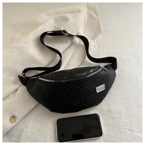 Detail of black woven chest bag with silver zipper and textured synthetic leather