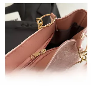 Detail of pink embroidered handbag showing smooth gold zipper and premium fabric texture