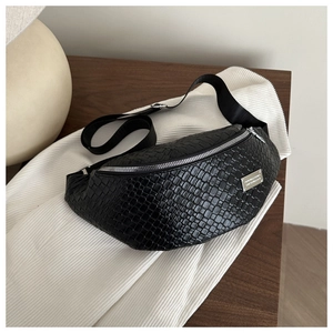 Detail of black woven texture chest bag with premium silver zipper and metallic logo plate