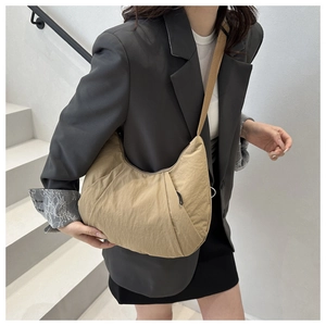 Sac croissant kaki porté par mannequin avec bandoulière large et nylon plissé