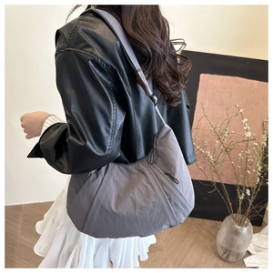 Sac hobo gris en nylon avec bandoulière réglable vu de côté sur un mannequin