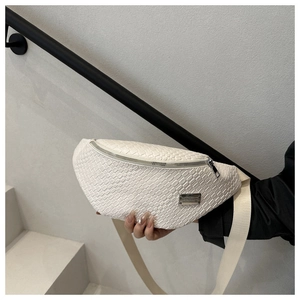 Detail of white woven chest bag with metal zipper and luxury textured leather finish