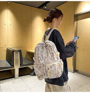 Close-up of marble pattern backpack on model in a cozy indoor setting