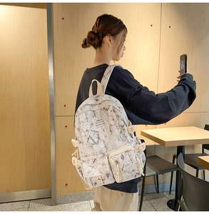 Detail of white marble print backpack with multi-pocket design and leisure college label