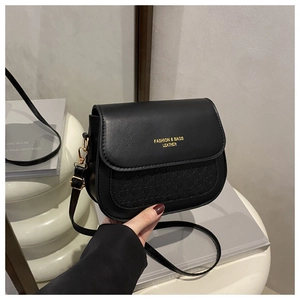 Detail showing black houndstooth embossed PU leather and gold logo on crossbody bag