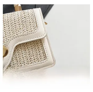 Detailed macro view of V-shaped straw weave and cream leather trim with gold metal clasp