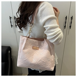 Detailed view of pink tote bag featuring 3D floral embroidery and gold chain strap
