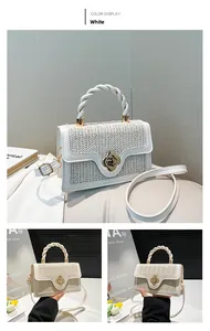 Detail of woven texture small square bag with golden flower clasp and knotted handle