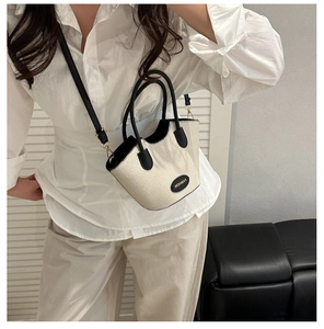 Détail du sac seau tissé crème avec poignées en cuir noir et logo Fashion élégant