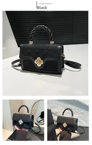 Detail of black woven handbag featuring twisted leather handle and gold flower twist lock