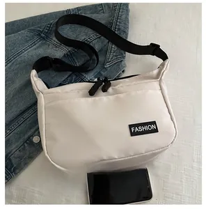 Détail du sac bandoulière en nylon montrant la taille par rapport au téléphone