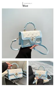 Detail of blue and white handbag featuring embossed texture and gold flower clasp