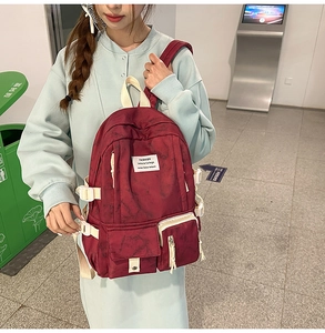 Side view of large capacity dark red marble patterned student backpack with fashion patches