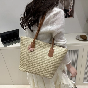 Straw woven tote bag with brown leather handles and pink butterfly embroidery