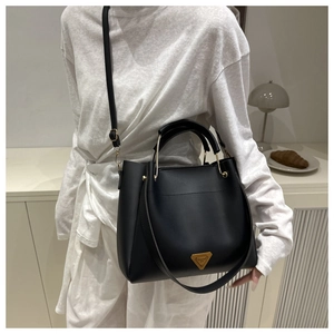 Detail of black leather bucket bag with golden triangle logo and adjustable shoulder strap