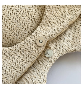 Vue macro de la boucle magnétique argentée et du tressage en paille du sac de plage été
