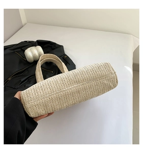 Gros plan sur le fond large et le tissage en épi serré de ce sac cabas en paille beige