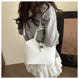 Chic white tote bag with silver hardware worn with a grey hoodie and lace skirt