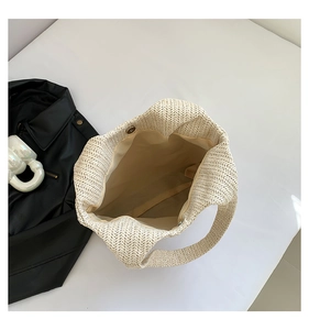 Vue intérieure du sac cabas en paille montrant la texture tissée et le fermoir aimanté