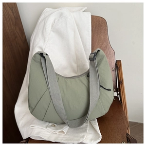 Détail du sac dumpling en nylon vert sauge avec texture plissée et sangle réglable