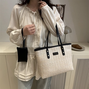 Chic beige straw tote bag with black leather straps and matching small pouch