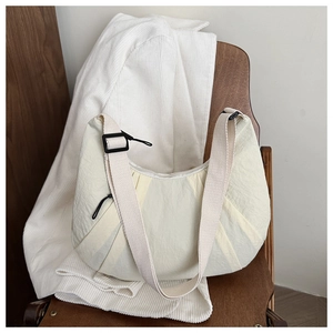 Gros plan sur le sac en nylon plissé blanc crème montrant la texture et la sangle
