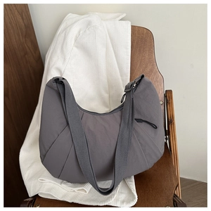 Détail du sac croissant gris foncé avec plis et bandoulière en tissu réglable