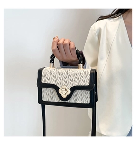 Detailed macro view of woven texture with golden clover-shaped metal clasp on crossbody bag