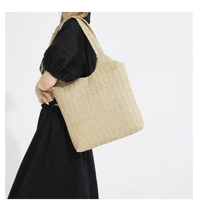 Détail d'un grand sac cabas en paille tissée avec motif à chevrons et anse souple