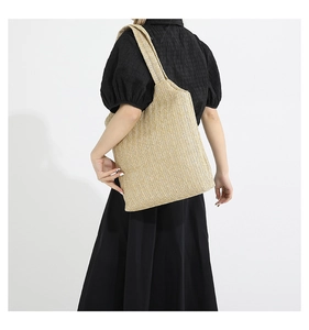 Détail du sac cabas en paille beige avec tissage en V et large bandoulière