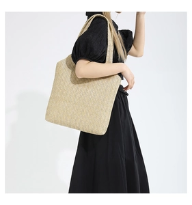 Photo de style de vie du grand sac cabas en paille tressée sur fond blanc neutre
