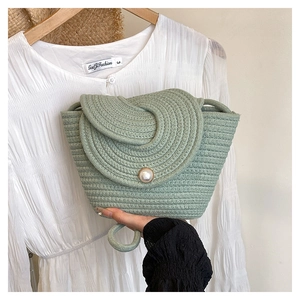 Détail du sac tissé en coton vert sauge avec fermoir perle et rabat élégant