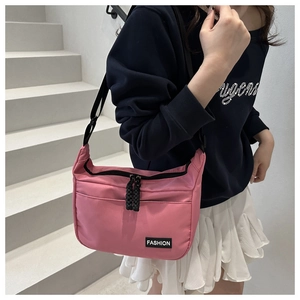 Détail du sac bandoulière en nylon rose avec sangle réglable et étiquette de mode