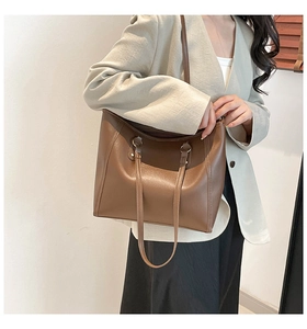 Detailed view of brown leather tote bag with long handles and spacious commute design