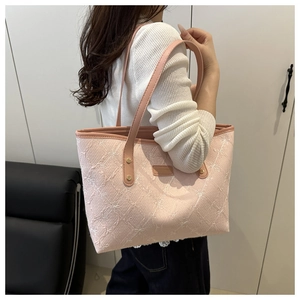 Detail of pink tote bag featuring 3D floral bow embroidery and thin shoulder straps