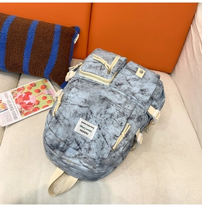 Detail of blue marble student backpack showing multiple pockets and durable fabric texture