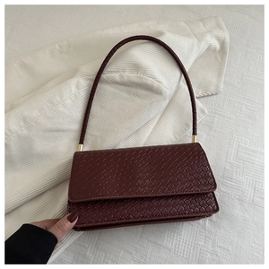 Detailed macro view of deep burgundy rectangular bag with fine woven texture and top handle