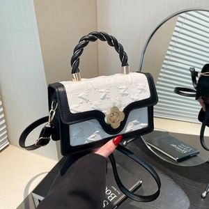 Detail of contrast handbag featuring white pleated texture and golden petal twist lock