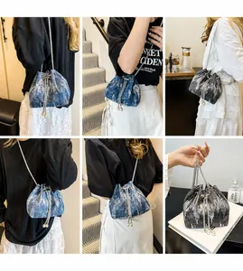 Detail of sequined denim bucket bags in blue and grey with pearl drawstring and chain