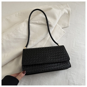 Detailed close-up of woven texture black shoulder bag with elegant gold metal hardware buckle