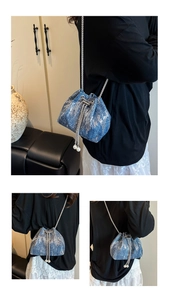 Detail of blue denim bucket bag featuring silver sequins and pearl drawstring accents