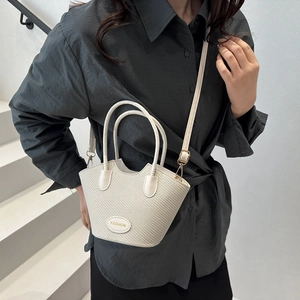 White woven bucket bag with fashion label shown in a modern minimalist setting
