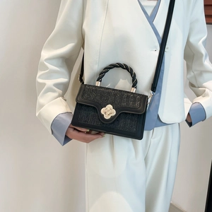 Straw texture crossbody bag in black with gold floral buckle and braided handle